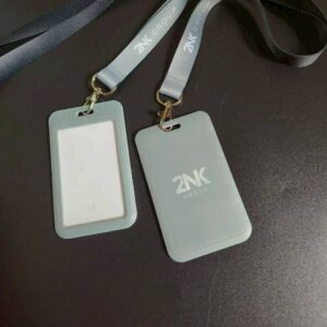 ตัวอย่างผลงานการสกรีนกรอบใส่บัตรพนักงานแนวตั้ง สีเทา พิมพ์โลโก้บริษัท 2NK